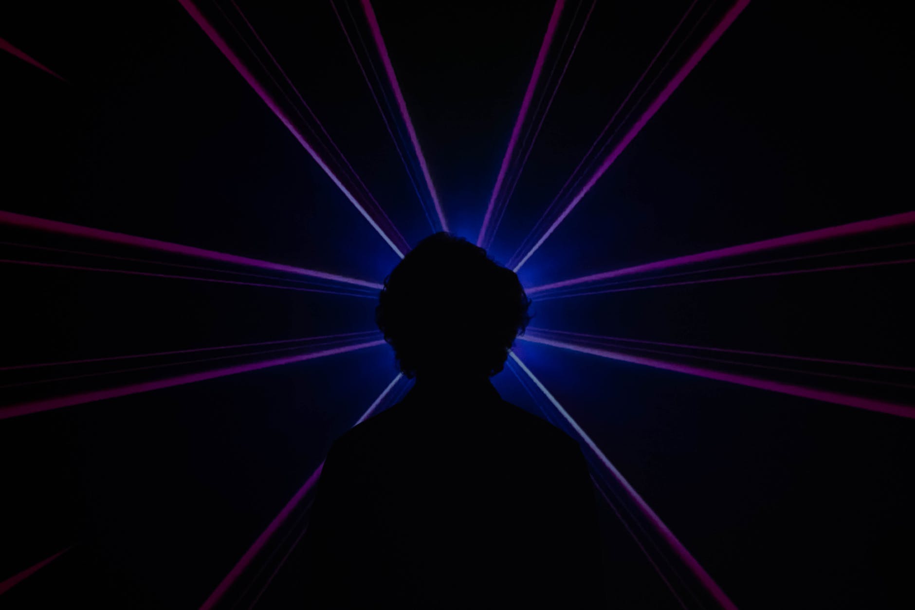 silhouette of man standing in front of purple light